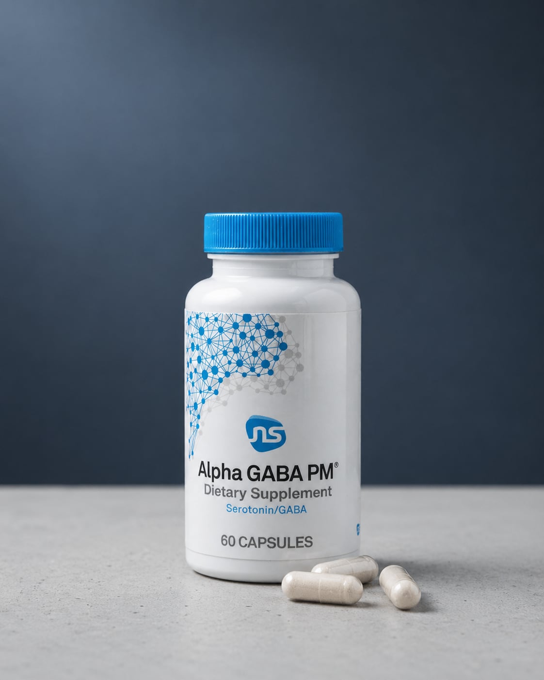 Alpha-Gaba PM bottle on a light grey concrete surface against a soft dark wall, with three white capsules resting in front