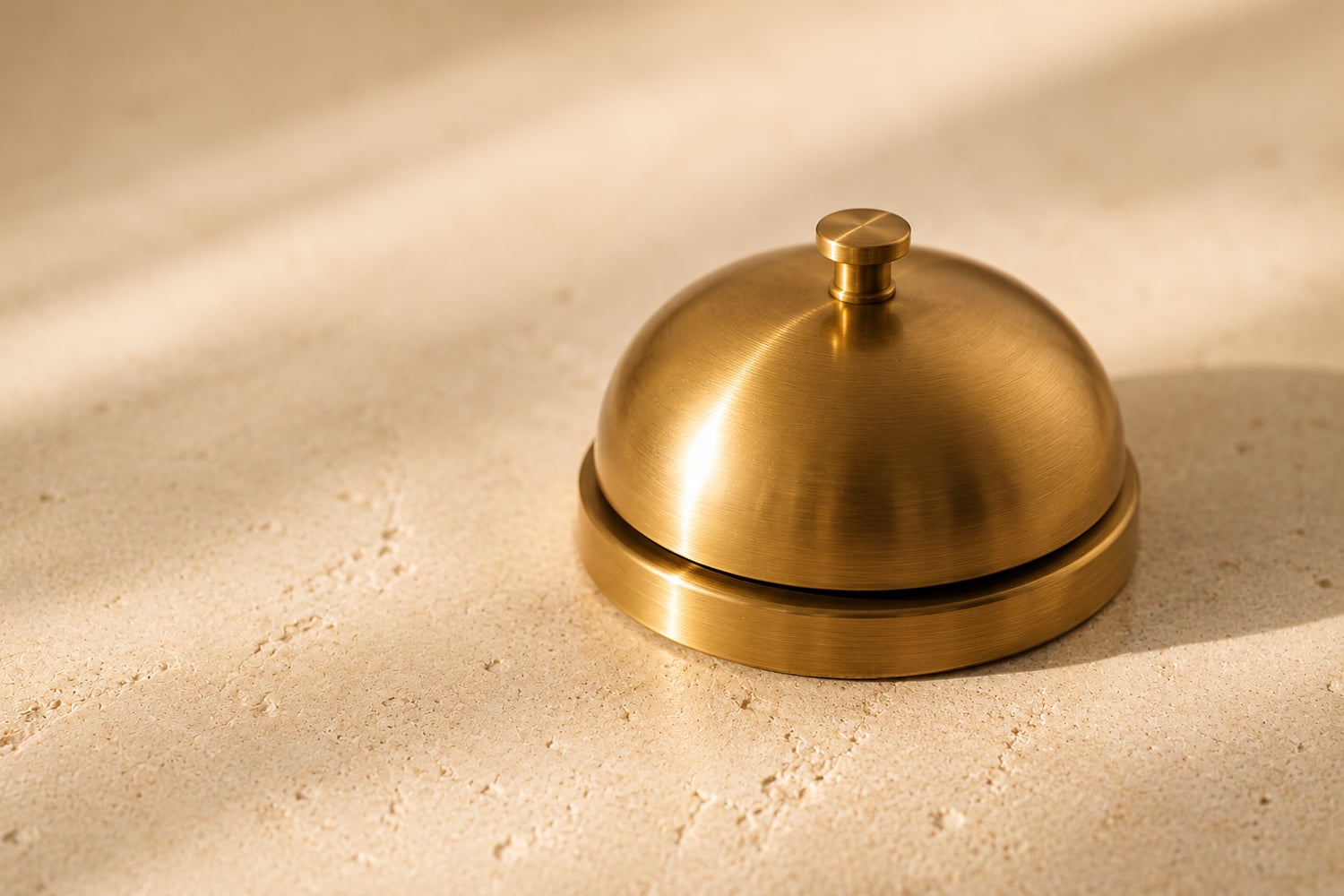A sleek modern call bell in warm golden light, service on call