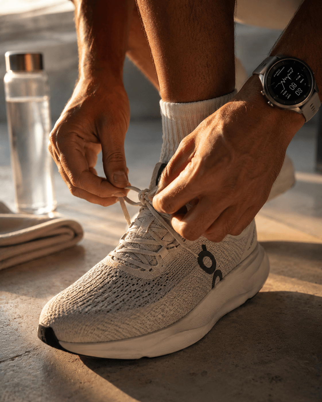 Hands lacing up high-performance running shoes at sunrise — the kinetic energy of someone operating at peak.